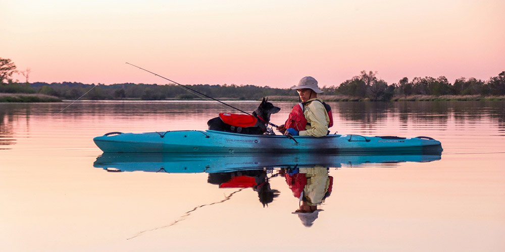 Man kayaking with a dog